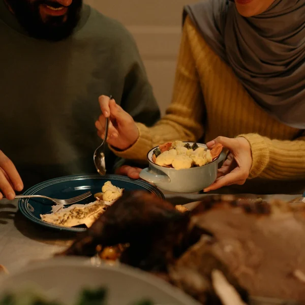 Personne âgée recevant de l'aide pour manger, moment de partage et de soutien à domicile